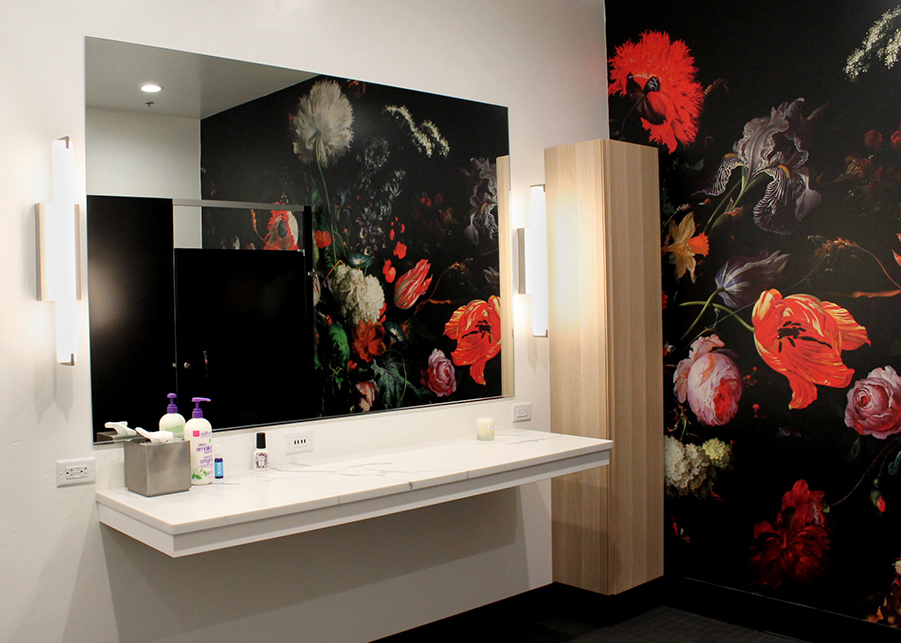 The bathroom at Sekse features delicate wooden lightboxes and a botanical wall mural